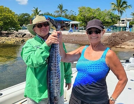 Man and woman holding a long fish on a boat in Islamorada.