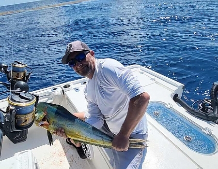 Man holding a large fish on a boat during Key Largo fishing charters.