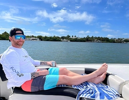 Man lounging on a boat with a drink during an Islamorada boat tour.