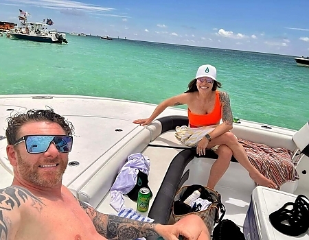 Couple relaxing on a boat in shallow water during a sandbar adventure in Islamorada.