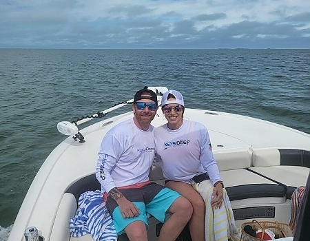 Two men sitting on a boat smiling during a Key Largo fishing charters trip.