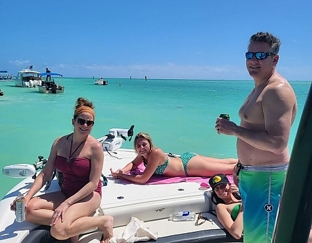 Group of people relaxing on a boat in shallow water during an Islamorada boat tour.