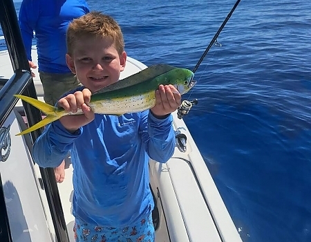 Boy holding a fish on a boat in Key Largo with Beyond Blessed Charters.