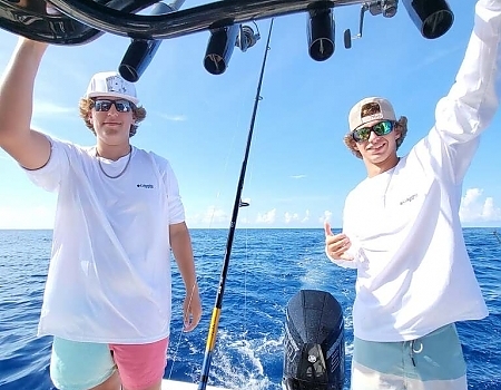Two young men on a boat with fishing rods in Key Largo.