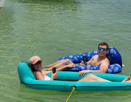 Couple relaxing on inflatable rafts in the water during an Islamorada boat tour.