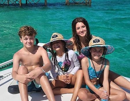 Four children sitting on a boat in shallow water during an Islamorada boat tour.