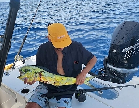 Man holding a large fish on a boat in Islamorada with Beyond Blessed Charters.