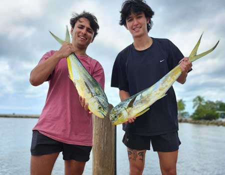 Two young men holding fish on a dock in Islamorada.