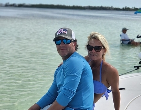 Man and woman sitting on a boat in shallow water in Islamorada.