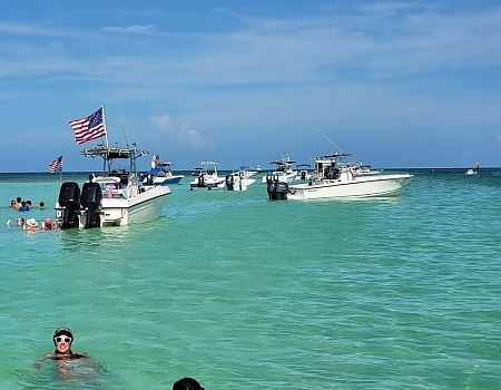 Boats anchored in shallow water with an American flag during an Islamorada boat tour.