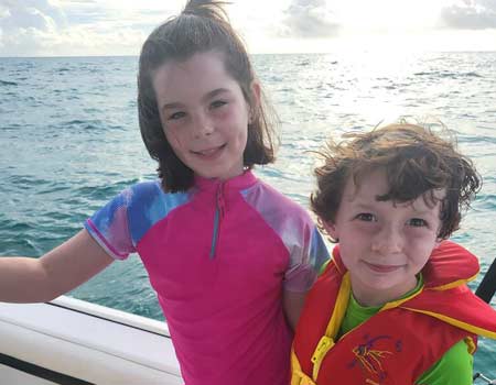 Two young children on a boat during a family fishing trip in Key Largo.